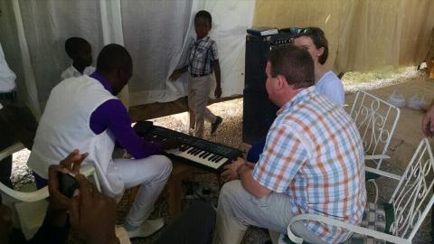 team members singing with haitians